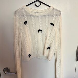 Cropped cream sweater with 3D black bow accents!